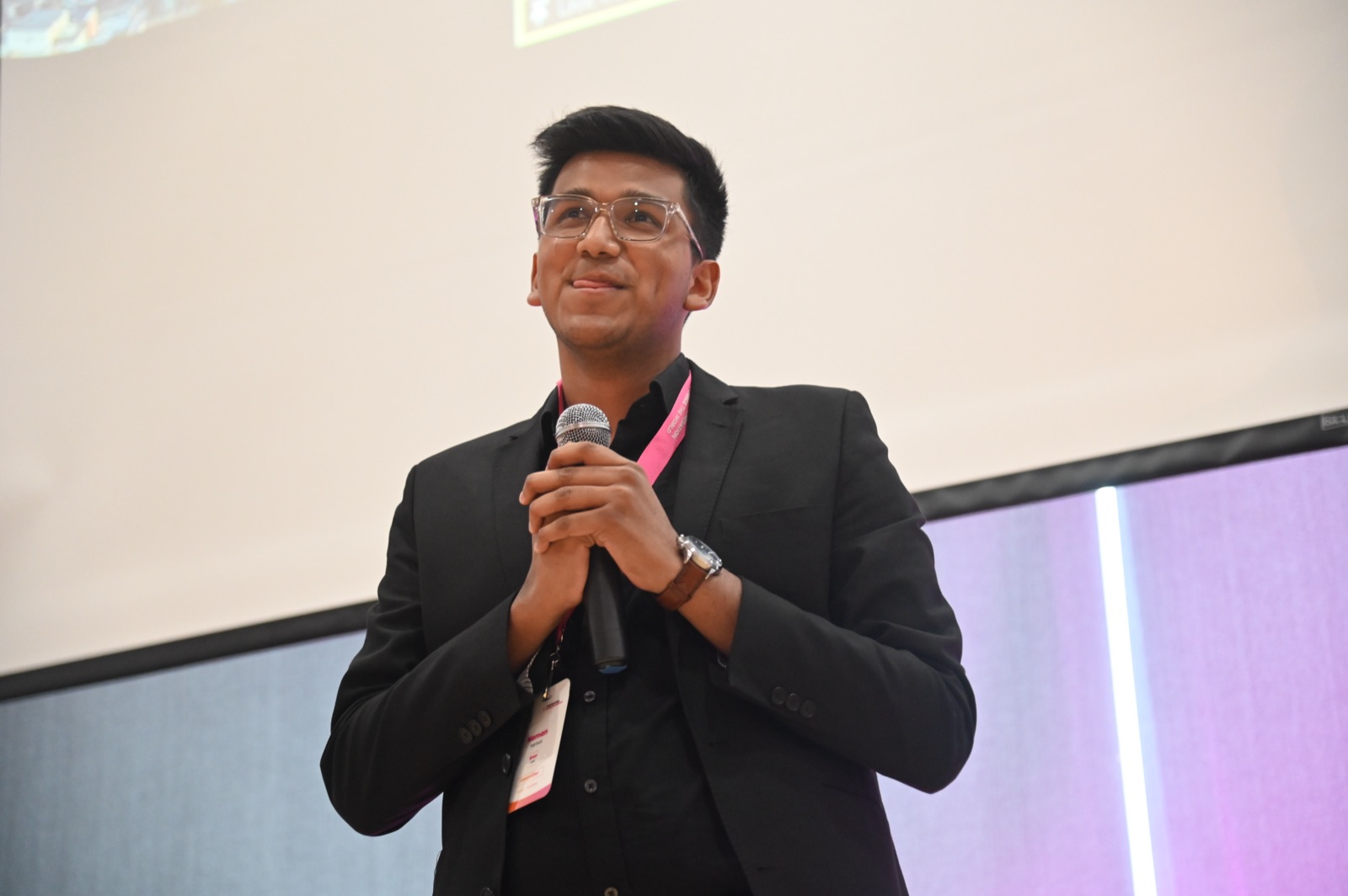 Naman Tekriwal speaking with a microphone